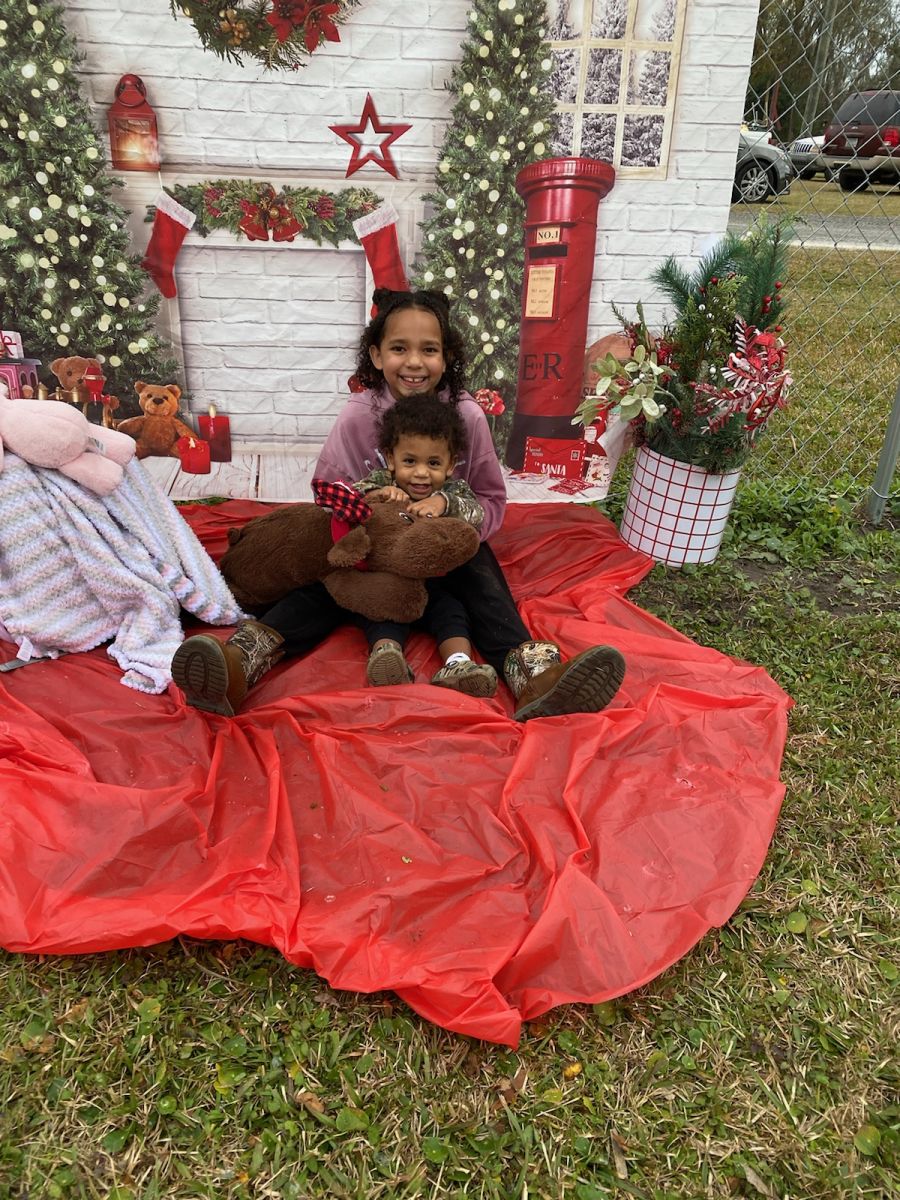 two kids holding brown stuffed animal