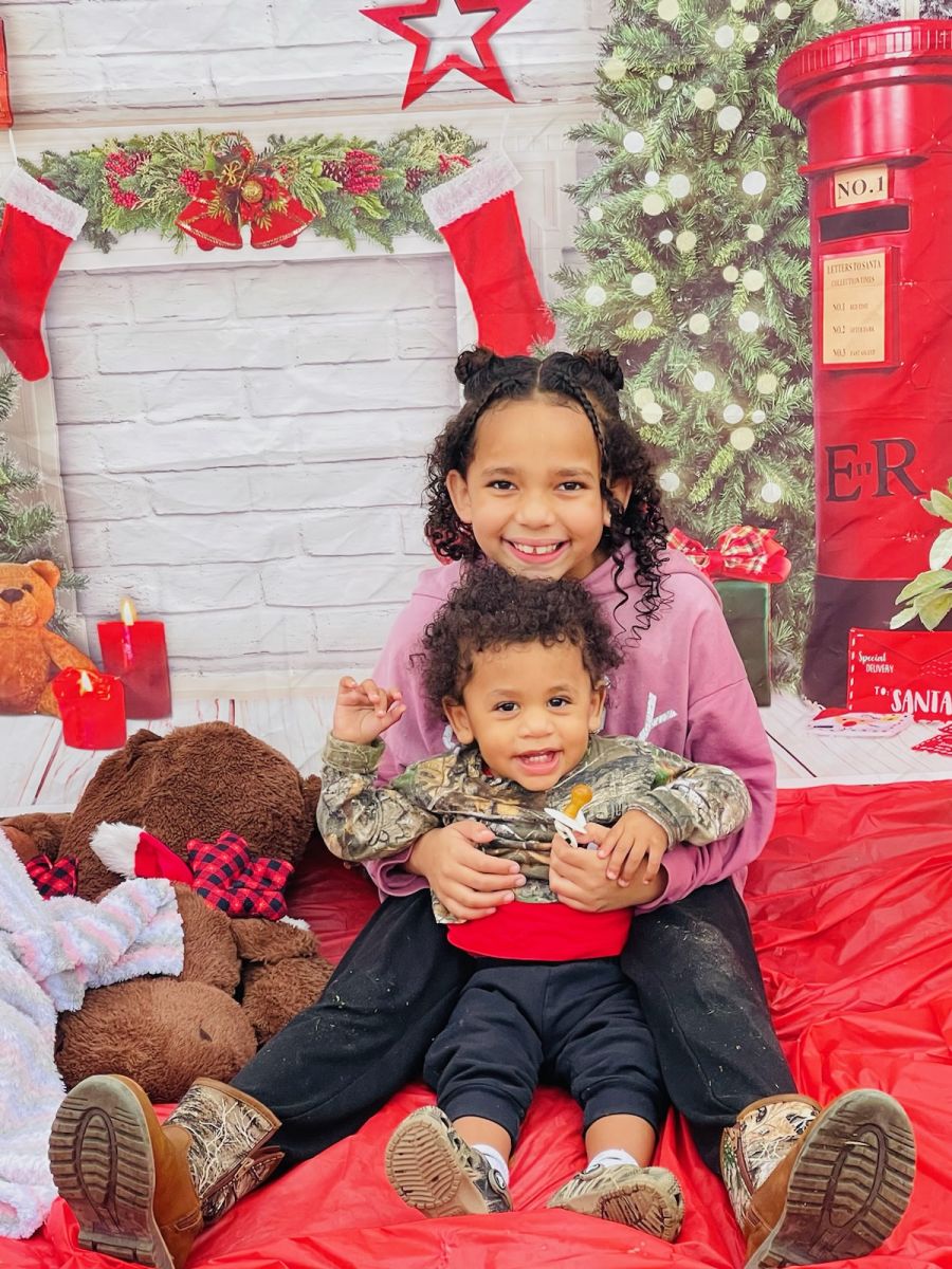 two kids holding brown stuffed animal